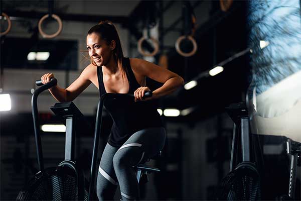 Young athletic woman doing cardio exercise in gym 