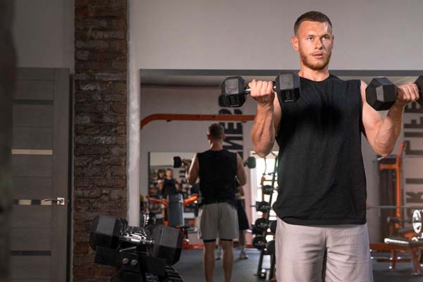 fit man holding dumbbells doing weight training 