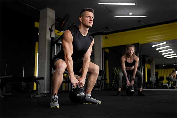 Man and woman doing strength training in gym