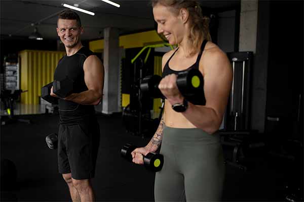Man and woman doing strength training with dumbbells 