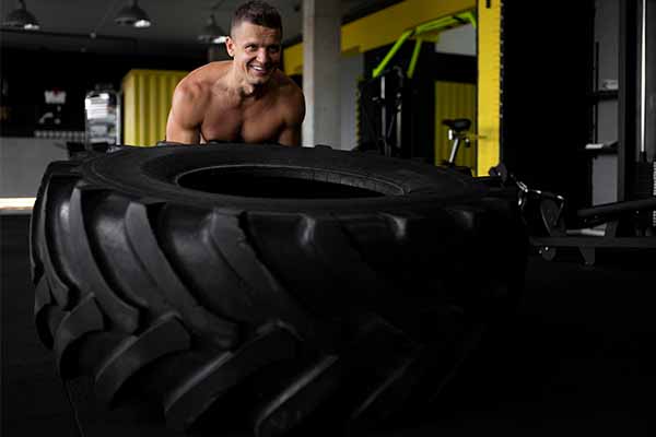 Man doing exercise using big tire