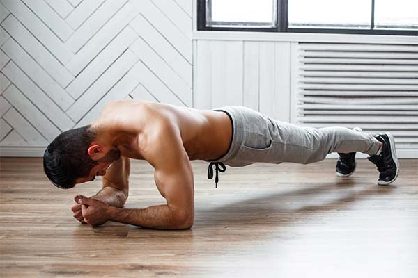 A man doing ab workouts on the floor.