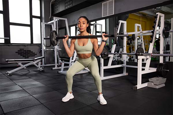 Woman training for weightlifting in gym for six pack abs 