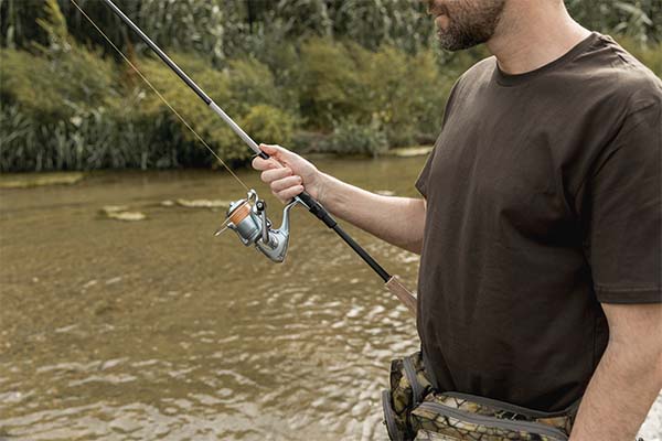 Man fishing at the river with fishing rods and reels