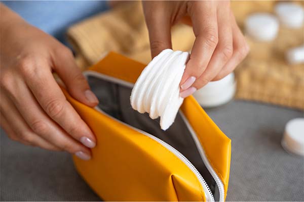 Woman putting cotton pads in pouch
