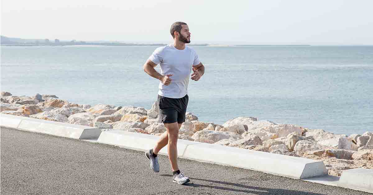 Man Running on Seaside Road wearing running gear