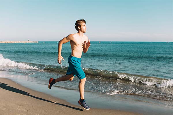 Guy sprinting at the beach