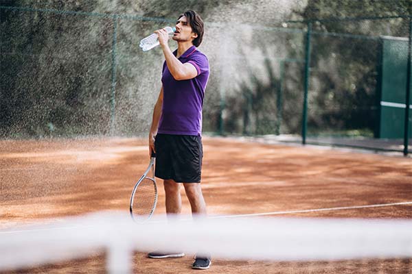 Man is drinking water on ground