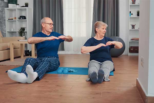 senior couple training together sitting on yoga mat. Old person healthy and active lifestyle exercise and workout at home, elderly training and fitness