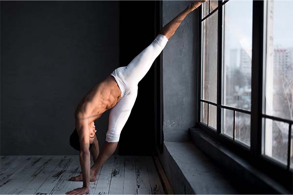Side view of male ballet dancer stretching in tights