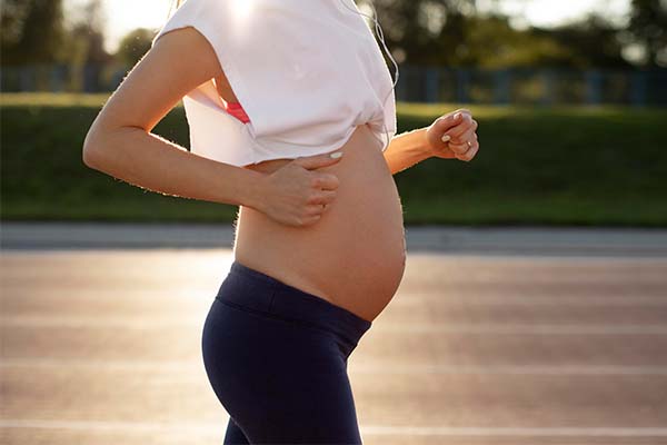 Young woman exercising during pregnancy with copy space