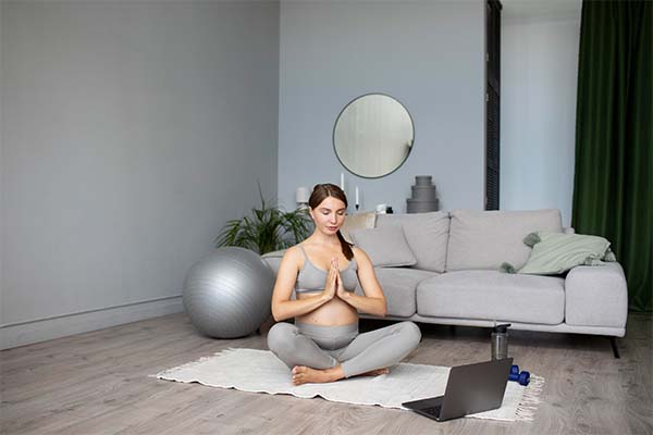 Pregnant woman doing yoga at home