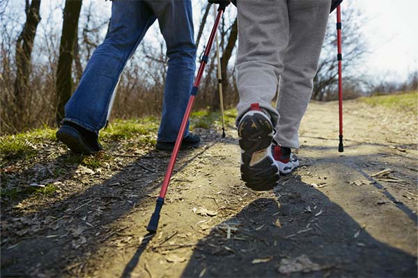 Man and woman walking using pole