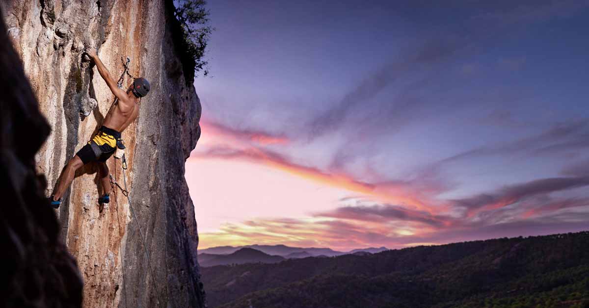Man climbing on a mountain with safety equipment