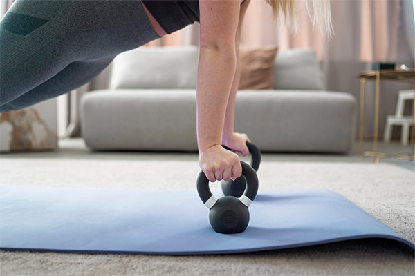 Woman training with kettlebell on mat