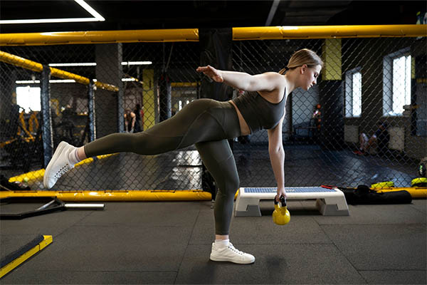 woman training with kettlebell at gym