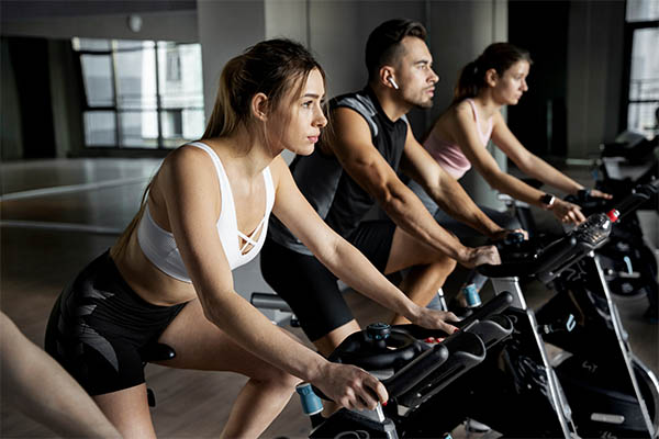 People doing indoor cycling in class