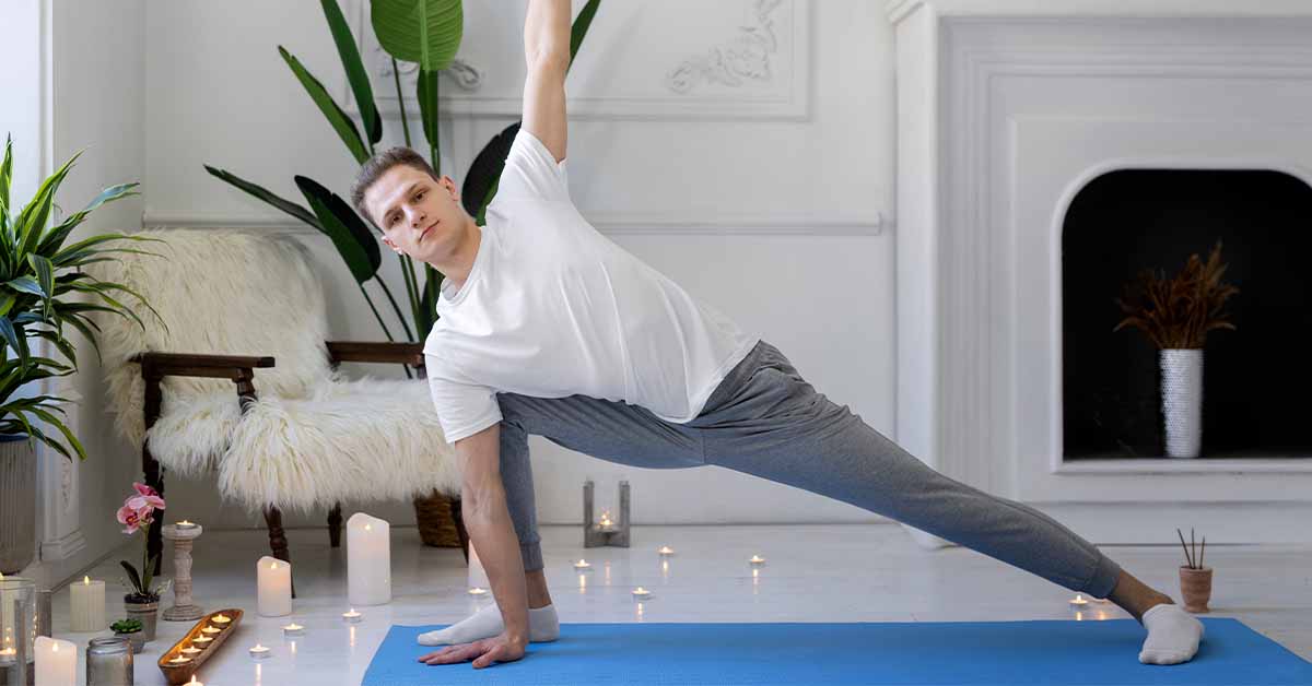 Man holding a side plank yoga pose in a peaceful, candle-lit room for stress management