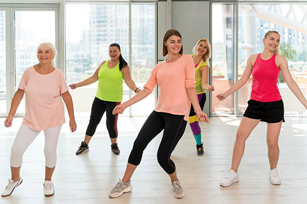 Group of women of various ages enjoying a fun dance fitness class.

