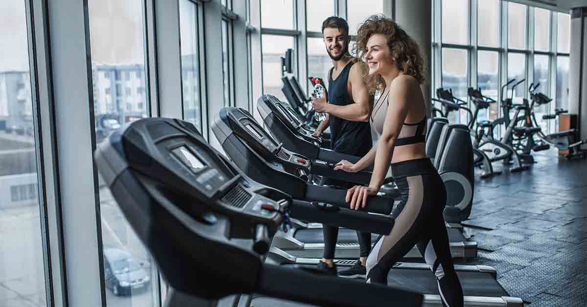 young sports couple making cardio workout in modern gym